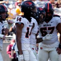 Oregon State Football players celebrate after play