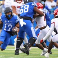 Kentucky football running back carries football